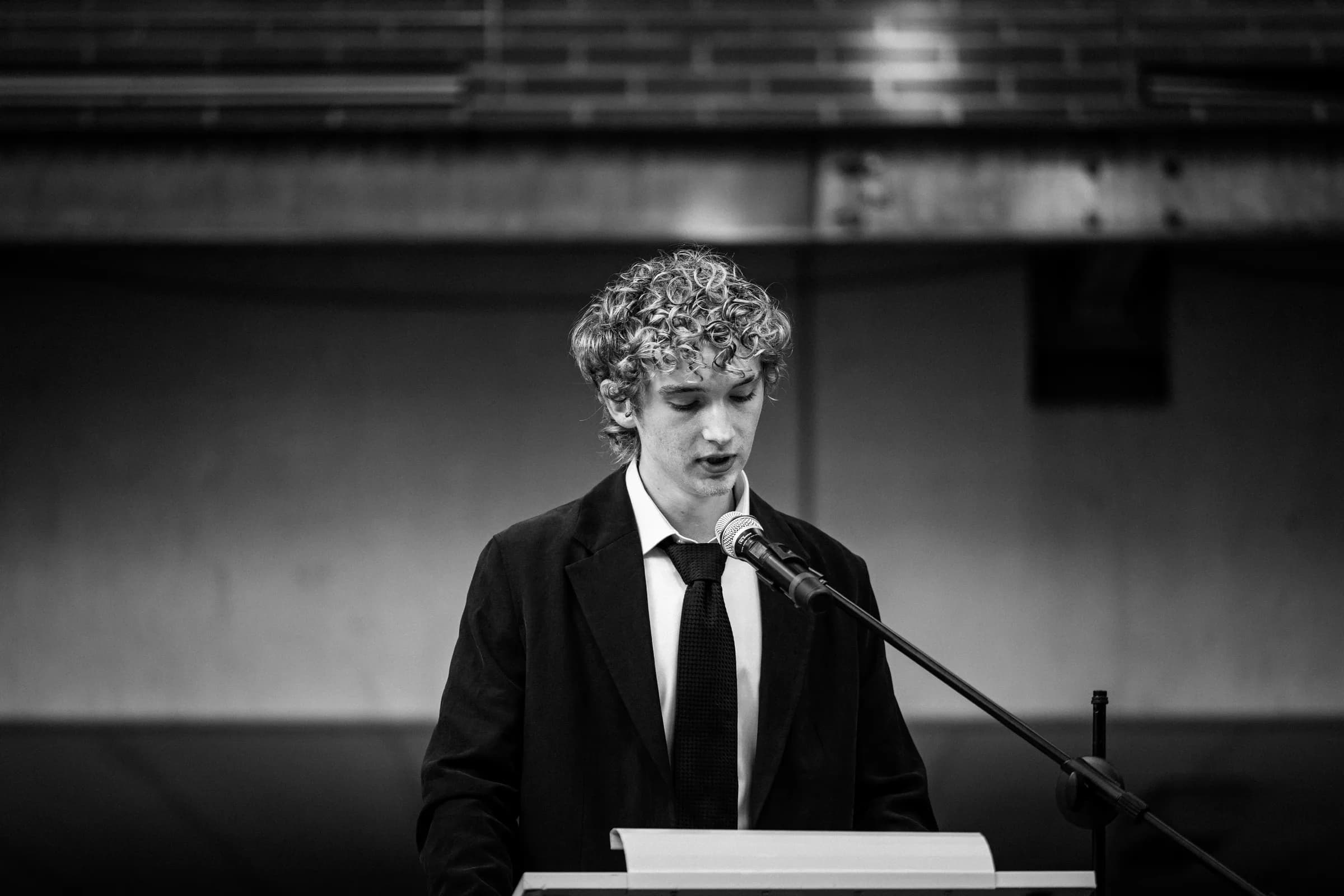 Abiturient hält Rede am Mikrofon – stimmungsvolles S/W-Portrait