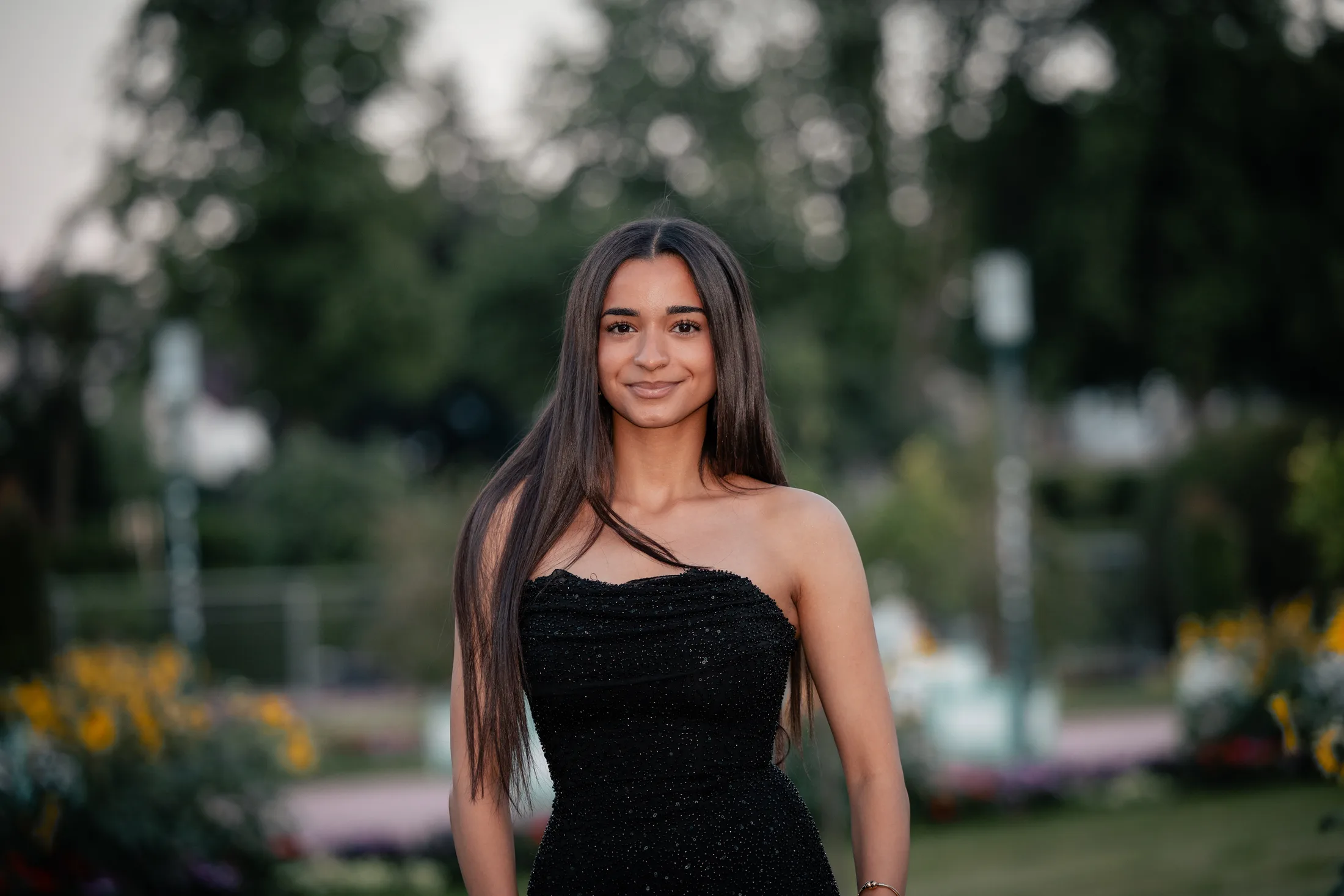 Junge Frau im schwarzen Trägerkleid in einem Garten, Beispiel für schlichtes Outfit mit ruhiger Farbe