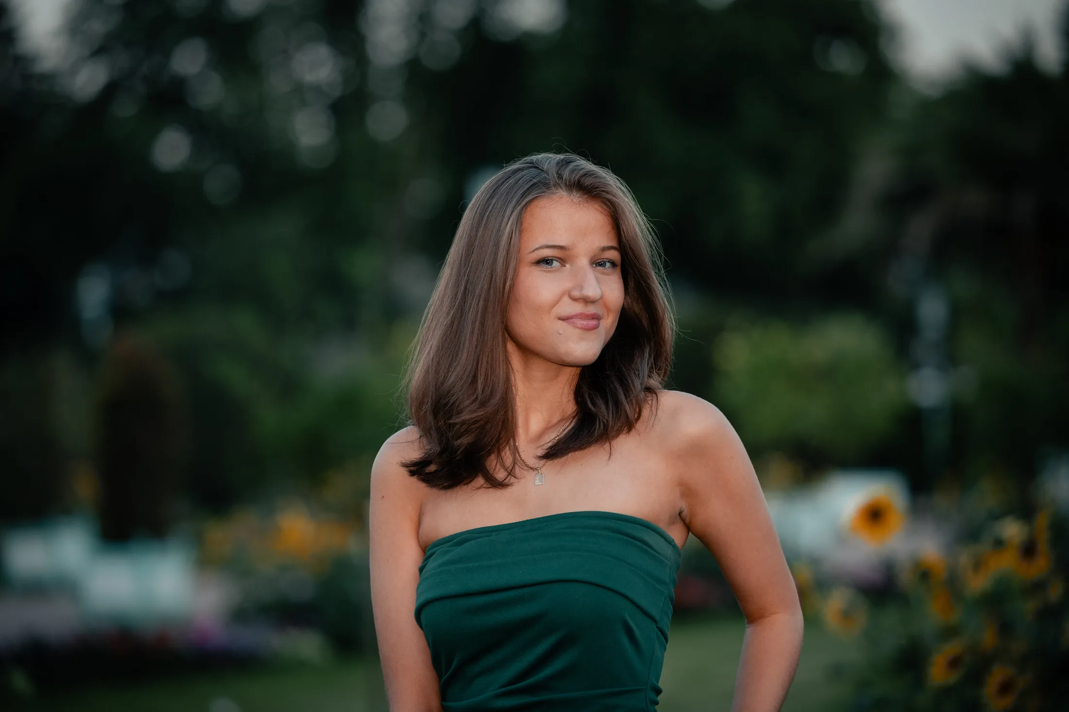 Junge Frau im grünen Trägerkleid in einem Garten