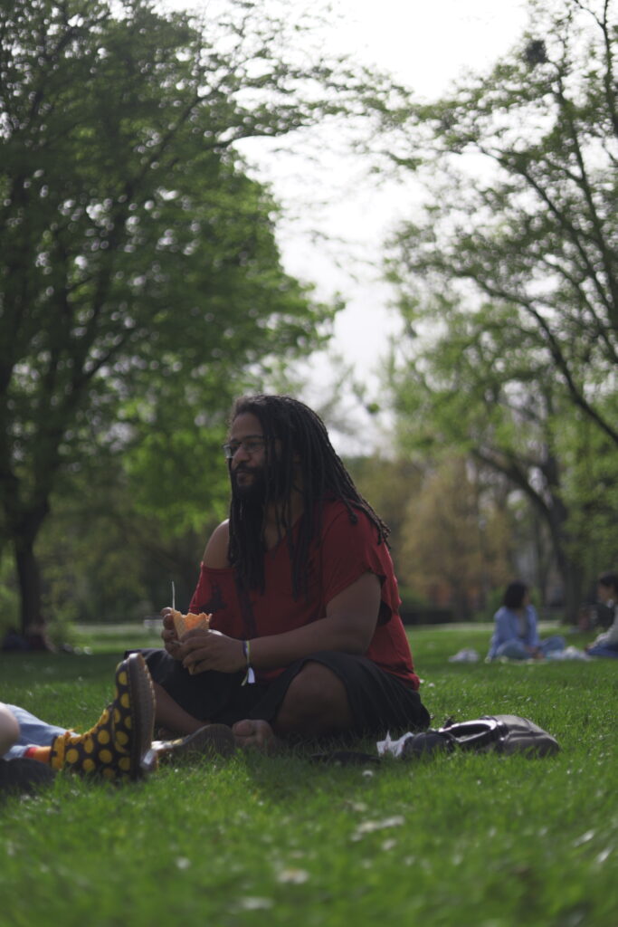 Portrait einer Person auf einer Picknickdecke im Park, weiches Licht und natürliche Pose.